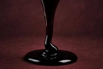 Nar ekşisinin akışı; koyu bordo tonlu yoğun şurup