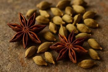 Yıldız anason ve kakule; sıcak baharat taneleri taş zemin üzerinde
