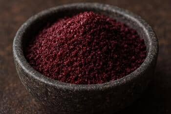 Koyu mor-kızıl sumak tozu, küçük taş kâsede