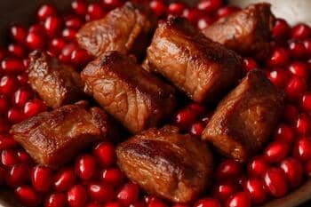 Nar taneleri ve kuzu eti: parlak kırmızı ile sıcak kahverengi kontrastı