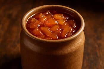 Taş kavanozda ayva reçeli: kehribar tonları ve ince şurup parlaklığı