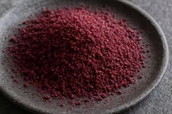 Taş tabakta serpilmiş sumak, mor-kızıl tonların dokusu